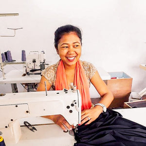 artisan smiling at sewing machine